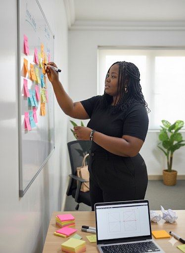 Instructor arranging sticky notes during a product design session.